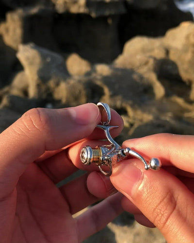 Video of a silver fishing reel v2 pendant by Castil. Shows fully rotatable handle and reel head.